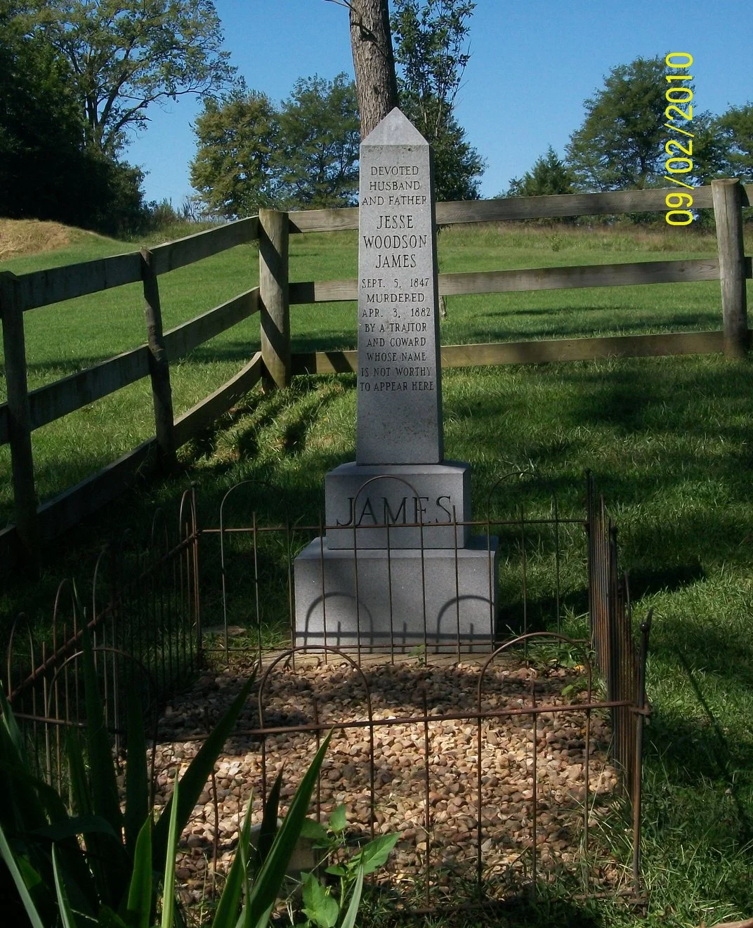 A picture of a grave which engraves: Devoted husband and father Jesse Woodson James Sept. 5, 1847, Murdered Apr. 3, 1882 by a traitor and coward whose name is not worthy to appear here. James